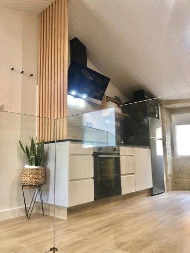 a kitchen with white cabinets and a potted plant at Casa Arrabal in Oia