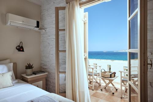 a bedroom with a bed and a view of the ocean at Naxos Magic Village in Stelida