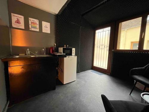 une cuisine avec un réfrigérateur blanc et une fenêtre dans l'établissement Les 50 nuances de rouge LOVEROOM, à Souppes-sur-Loing