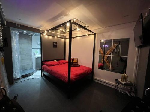 a bedroom with a canopy bed with lights on it at Les 50 nuances de rouge LOVEROOM in Souppes-sur-Loing