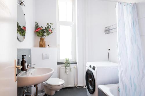 a white bathroom with a sink and a toilet at Sonnig und Helle Wohnung Alexanderplatz in 15min zu erreichen, sehr schön und groß für Gruppen geeignet in Berlin