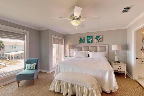 1 dormitorio con 1 cama blanca y 1 silla azul en After Dune Delight - 626 Beachview Drive, en Saint Simons