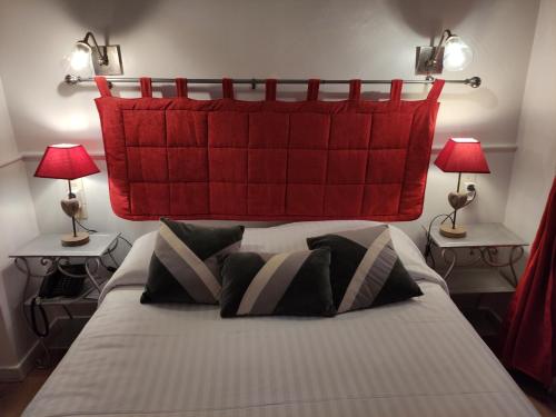 a bedroom with a large bed with a red headboard at Le Pavillon Saint-Martin in Souillac