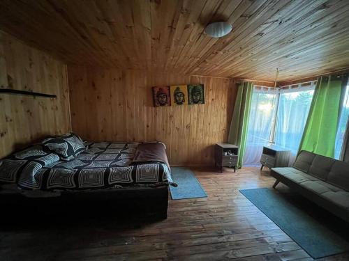 a bedroom with a bed and a couch and windows at Parcela de agrado orilla de lago in El Estero