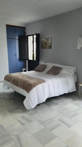 1 dormitorio con 1 cama grande con sábanas blancas en CASA MORENA MiA APARTAMENTOS en Granada