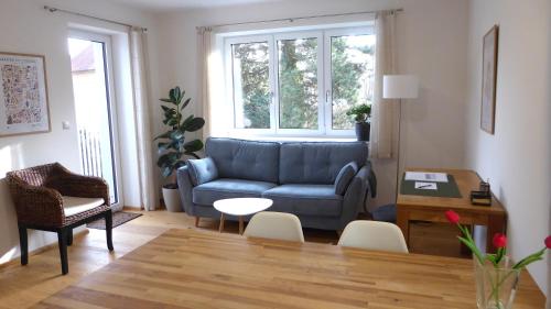 a living room with a blue couch and a table at Wohnen im schönsten Viertel Wiens in Vienna