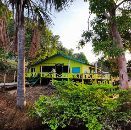 una casa amarilla y azul en medio de árboles en Lodge Lake View, en Manaus