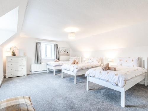a bedroom with three beds in a room at Church View in Hunstanton