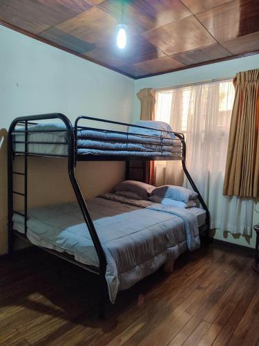 a bunk bed in a room with a window at The Cozy Cactus House Cartago Centro English Spoke in Cartago