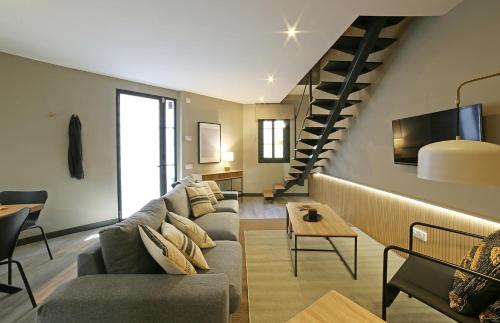 sala de estar con sofá y escalera en Fridays Flats Onix House, en Barcelona