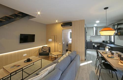 a living room with a blue couch and a table at Fridays Flats Onix House in Hospitalet de Llobregat