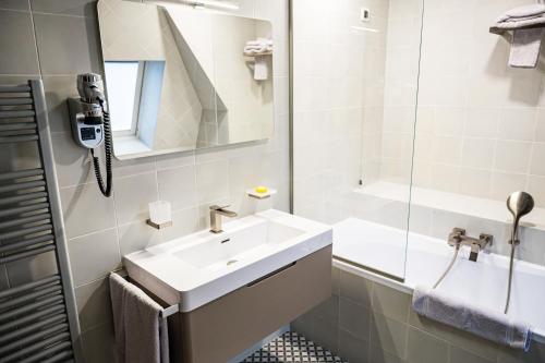 a white bathroom with a sink and a mirror at Villa Prato in Braşov