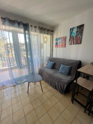 - un salon avec un canapé et une table dans l'établissement Petit T2 proche de la plage, à Sète