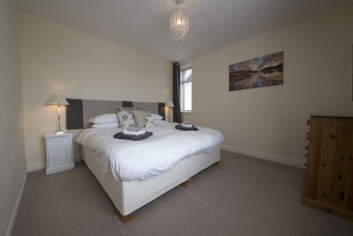 a bedroom with a white bed and a window at Buzzard's Reach formerly Rose Loft Coniston in Coniston