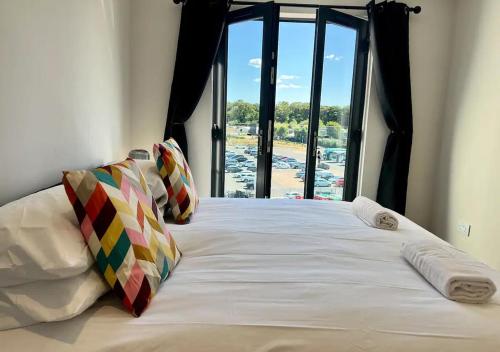 a bedroom with a large bed with a large window at Margate Main Sands Sea views Central Location Sleeps 4 in Kent