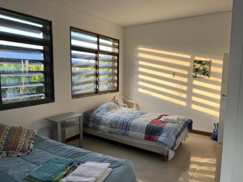 a bedroom with two beds and two windows at Plaza Independencia in Mendoza