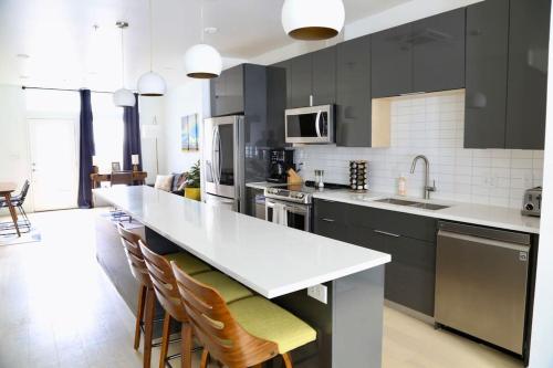 una cucina con armadi neri e piano di lavoro bianco di Upscale 2BR Condo w Patio, City Views, Walk to DT Austin ad Austin