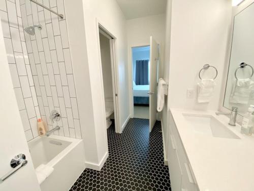 un bagno bianco con 2 lavandini e una doccia di Upscale 2BR Condo w Patio, City Views, Walk to DT Austin ad Austin