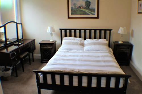 um quarto com uma cama grande, 2 mesas de cabeceira e uma secretária. em Moleside Cottage em Marden