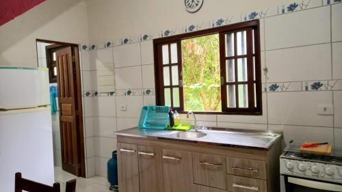 a kitchen with a sink and a window at Casas Jacatirão in Ubatuba
