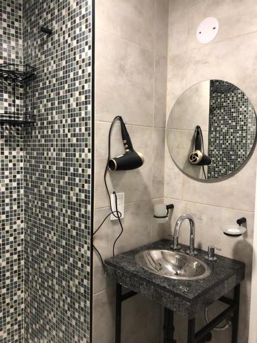 a bathroom with a sink and a mirror at Usina Studio by FMA Coliving in Salta