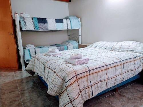 a bedroom with a bed with a plaid blanket at La Ponderosa in Caleta Olivia