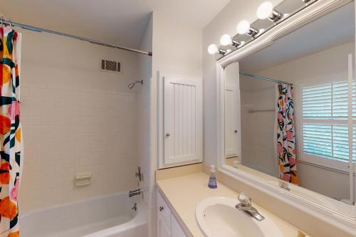 uma casa de banho branca com um lavatório e um espelho em Coastal Dream - 2232 Ocean Rd em Saint Simons Island