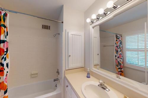 a white bathroom with a sink and a mirror at Coastal Dream - 2232 Ocean Rd in Saint Simons Island