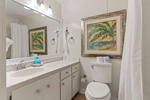 La salle de bains est pourvue d'un lavabo, de toilettes et d'un miroir. dans l'établissement Beachcomber, Unit 302, à Demere Park