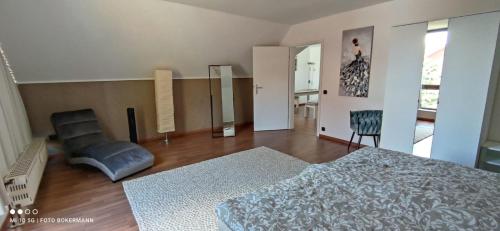 a bedroom with a bed and a chair in it at Ferienwohnung S+F Bokermann in Hörstel