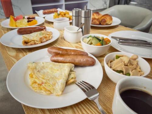 a table with plates of breakfast food on it at GolfHill Apartment in Kigali