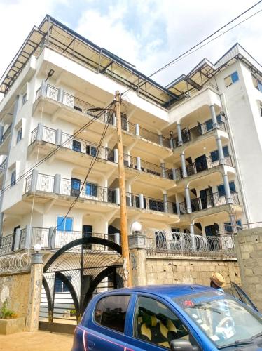 a blue car parked in front of a building at APEX ANNEX Guest Facility in Buea
