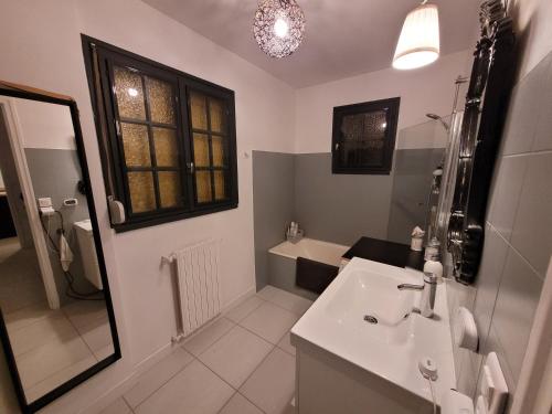 une salle de bain blanche avec un lavabo et un miroir dans l'établissement Chez Aurélie et Nicolas, à Brest