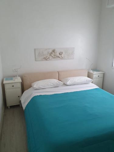 a bedroom with a blue bed with two night stands at La Casa Sul Lago in Salò