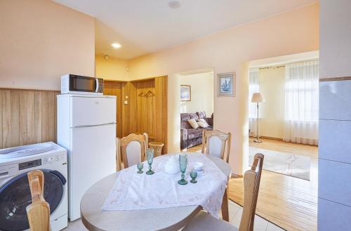a kitchen and dining room with a table and a refrigerator at Kurpių gatvė in Kaunas