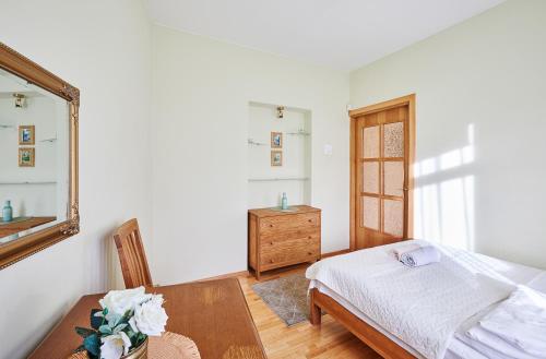 a bedroom with a bed and a table and a mirror at Kurpių gatvė in Kaunas
