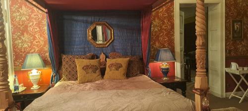 a bedroom with a bed with two lamps and a mirror at Villa am Stechlin in Neuglobsow