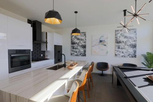 uma cozinha com um balcão com cadeiras e uma mesa em Luxury Penthouse w Glass Wall, Roof Deck, Firepit in DT Austin em Austin