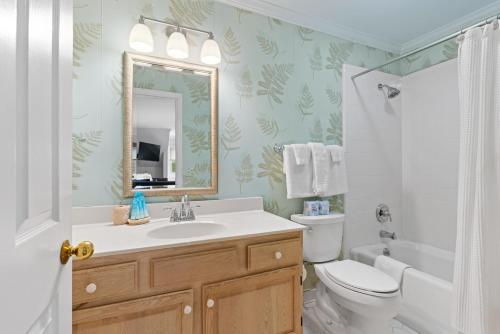 La salle de bains est pourvue d'un lavabo, de toilettes et d'un miroir. dans l'établissement Pelican's Porch - 4318 Eighth Street, à Île de Saint-Simon