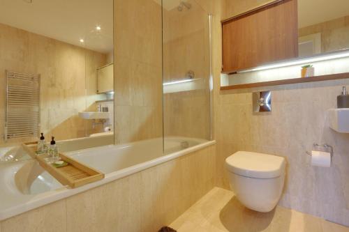 a bathroom with a tub and a toilet and a sink at View of the City - Fantastic, Spacious 2 Bed Apartment, Netflix, Stunning Views, Sheffield City Centre in Sheffield