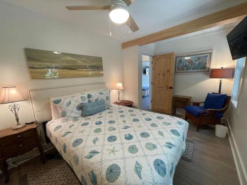 a bedroom with a bed and a blue chair at Tree Spirit Retreat - 4310 Third Street in Saint Simons Island