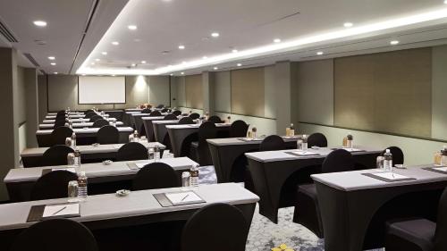a conference room with tables and chairs and a screen at Holiday Inn Bangkok by IHG in Bangkok