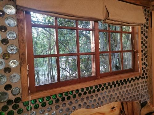 a window in a room with dishes on the wall at Cabaña Amor de los Tronquitos, Camino Villarrica in Villarrica