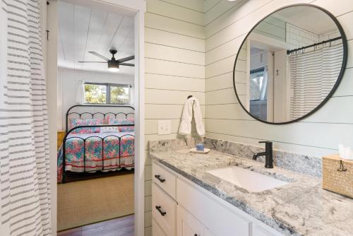a bathroom with a sink and a mirror and a bed at Three Oaks Beach Cottage - 2215 Bruce Drive in Saint Simons Island