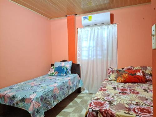大衛的住宿－Hostal Familiar Noemi，一间卧室设有两张床和一个带加热器的窗户。