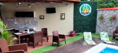 a patio with a table and chairs and a tv at Casa 24 Puerto Iguazu in Puerto Iguazú