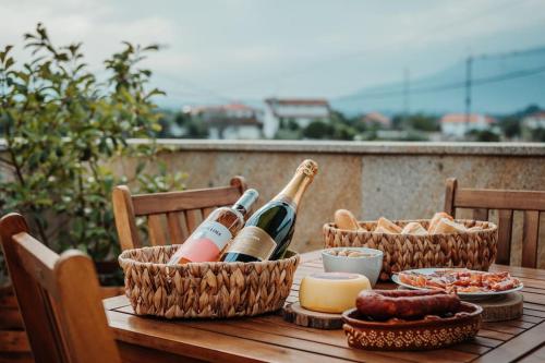 una mesa con botellas de vino y queso. en Villa Henriques, en Ponte de Lima