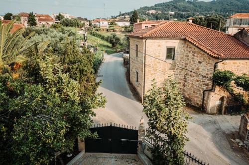 a house with a garage and a street with trees at Villa Henriques in Ponte de Lima