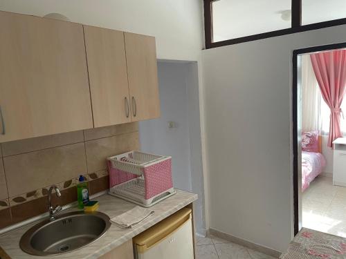uma cozinha com um lavatório e um quarto com uma cama em Apartments Plaza em Ulcinj
