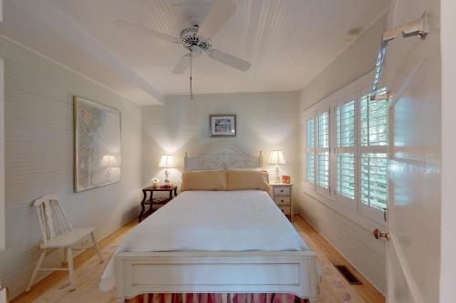 ein weißes Schlafzimmer mit einem Bett und einem Fenster in der Unterkunft You are my Sunshine - 4213 Fifth Street in Saint Simons Island